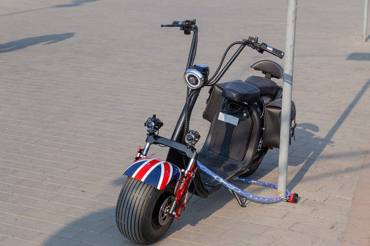 Lutsk, Ukraine - 04-05-2019: Electrical bike is paked on the pedestrain walk road with a chain and a padlock.