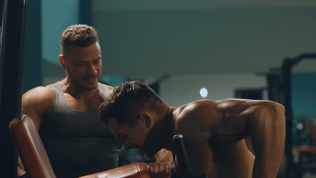 Two bodybuilders strong athletic men pumping up muscles workout fitness and bodybuilding concept background - muscular bodybuilder fitness men doing arms abs back exercises in gym naked torso