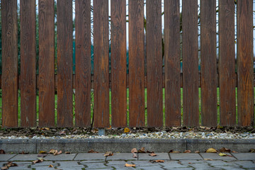 wooden fence in front of green garden of family house