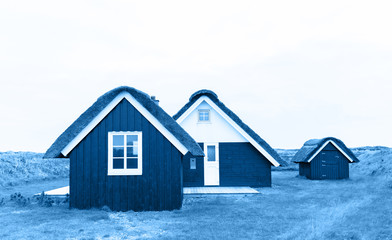 Image of rustic wooden Danish houses tinted in trendy blue color of the year 2020