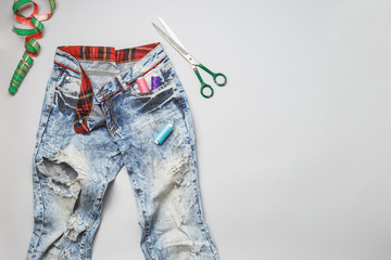 Old raped jeans with and sewing tools top view - obrazy, fototapety, plakaty