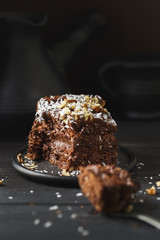 Chocolate cake in black plate on wooden table