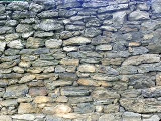 Old stone wall made of gray natural stone, texture stone background