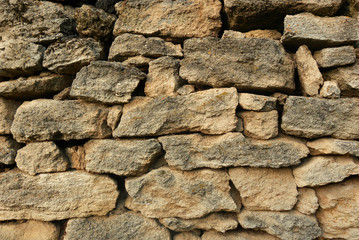 Fototapeta premium Old stone wall made of gray natural stone, texture stone background