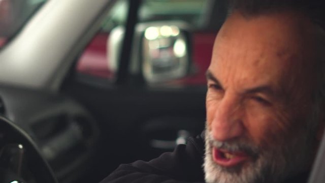 Smooth & steady slow motion portrait of a happy man in his car getting ready to go!
