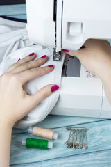 Obraz na płótnie Canvas Hands on the sewing machine