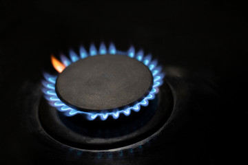Burner with flame in the dark, closeup. Blue and red flame. Gas supply to consumers.