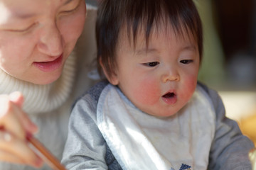 お母さんと一緒に食事する赤ちゃん