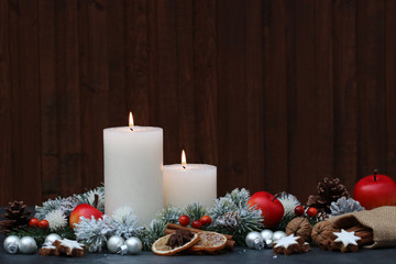 Burning candles with apples and nuts