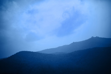 Blue mountains under the clouds. Nature tinted background, place for your text.