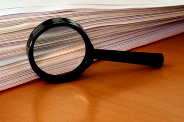 Paper Stack and Magnifying Glass