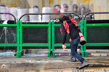 Manifestante protesta frente a la policía antidisturbios en la calle