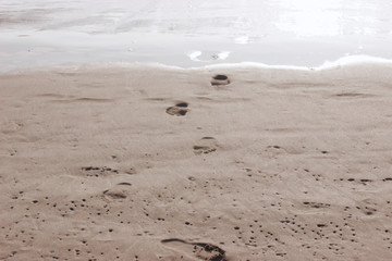 Footprints come out of the sea.