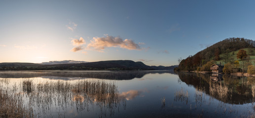 Epic vibrant sunrise Autumn Fall landscape image of Ullswater in Lake District with golden sunlight