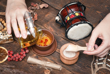 Witch doctor is preparing a magic potion on her table.