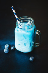 Trendy blue matcha drink on dark background.