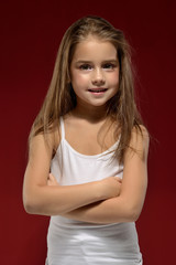 portrait of a little beautiful girl in a white T-shirt on a black background. Emotions