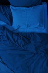 Bed linen of the blue classic blue color of the 2020 year.  Concept of the color of the year with copy space. The texture of the fabric.