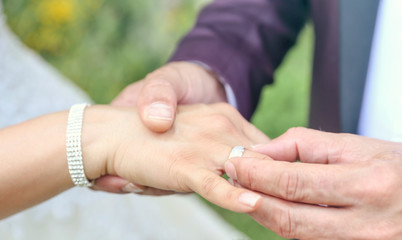 groom's hand putting a wedding ring on the bride's finger. Wedding ceremony. 