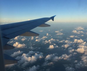 wing of an airplane flying above clouds