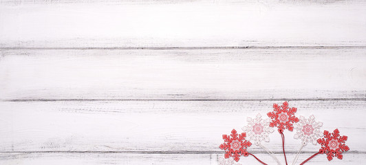Red and white wooden snowflakes toys for Christmas tree on white wooden table background