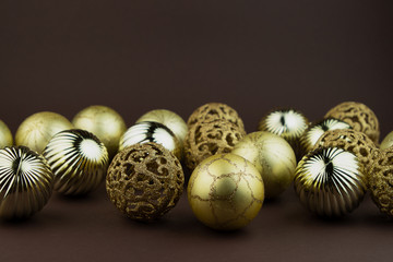 Golden sparkly Christmas balls on brown background. Magic holiday card. Christmas or New Year festive composition.