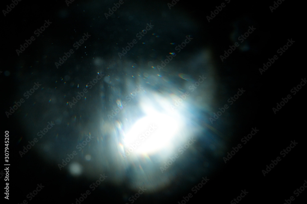 Poster Light over black background. Easy to add overlay or screen filter over photos. Abstract sun burst with digital lens flare background. Gleams rounded and hexagonal shapes, rainbow halo.