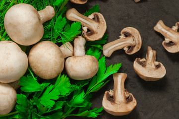 PORTOBELLO MUSHROOM on black plate. Dark background, top view. ,Champignon mushrooms on a black background. Space for text