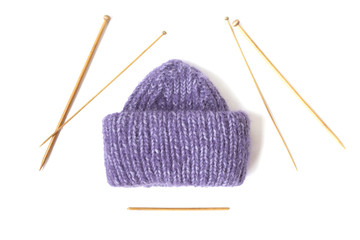 Knitted hat and wooden needles on the white background