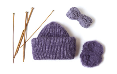 Knitted hat, needles and yarn balls.