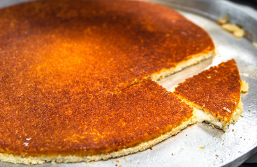 kunefe dessert made in a large tray. A dessert of cheese made in turkey
