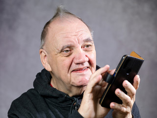 portrait vieil homme jouant sur son smartphone