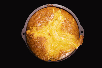  Homemade cake comes out of the oven, still in its silicone mold, on a black background