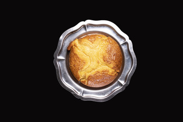 Cake in a silver dish, on a black background