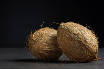 Organic natural whole coconut fruit on rustic background, tropical healthy food concept, Cocos nucifera