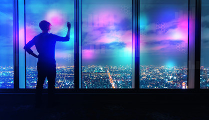 Digital graphs and hexagon grids with man writing on large windows high above a sprawling city at night