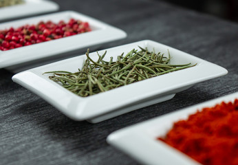 Rosemary herb. Colorful spices in white bowls Seasonings for cooking. Natural Herbs & Spices.