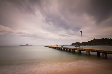 Fototapeta na wymiar a long pier above the sea on a cloudy day