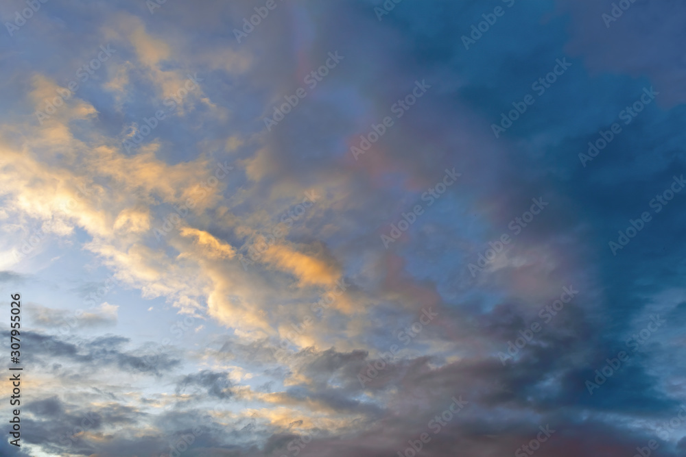 Wall mural the sky at sunset. cumulus clouds lit by the rays of the setting sun.