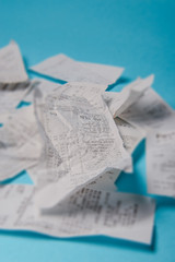 Pile of shopping receipts on blue background