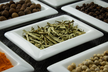 Tarragon leafs. Colorful spices in white bowls Seasonings for cooking. Natural Herbs & Spices.