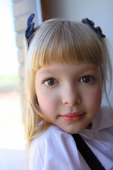 Nice cute sweet tender cheerful positive small little girl with curly pony-tails in white formal shirt and blue skirt asian schoolgirl