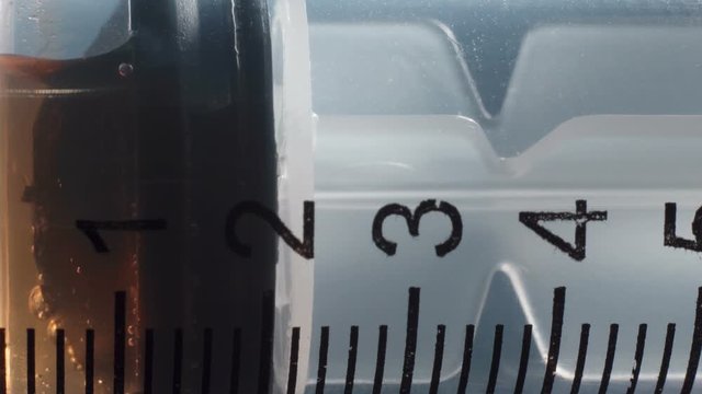 Video of medical syringe and brown vaccine