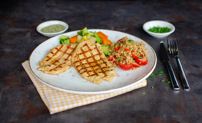 Grilled chicken fillet with boiled fresh vegetables and rises.