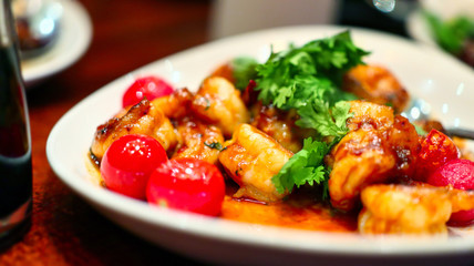 prepared saucy prawns dish with parsley and cherry tomatoes