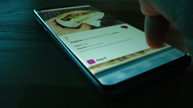 Close-up Macro: Person Using Smartphone, Browsing through Pictures on Social Network Wall. Finger Scrolling Social Media App Feed for Sharing Travel, Food, Selfie Photos. Mock-up Application Design