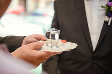 Traditional polish greeting the bride and groom by the parents with bread and salt. Vodka also in glasses