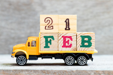 Truck hold letter block in word 21feb on wood background (Concept for date 21 month February)