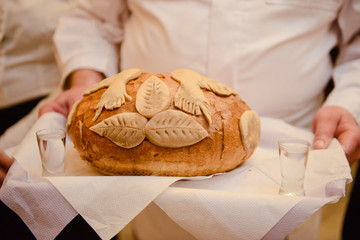 Traditional polish greeting the bride and groom by the parents with bread and salt. Vodka also in glasses