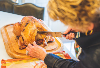 Woman cuts a prepared turkey